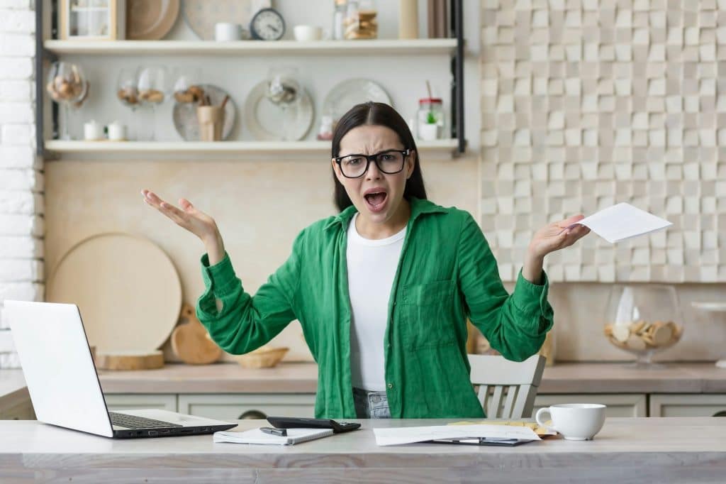 Tired young single mother feeling stressed because of financial problems, working through