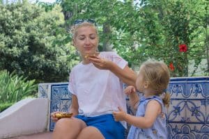 Mother and daughter eating Pasteis de Belem egg tart, typical Portuguese dessert